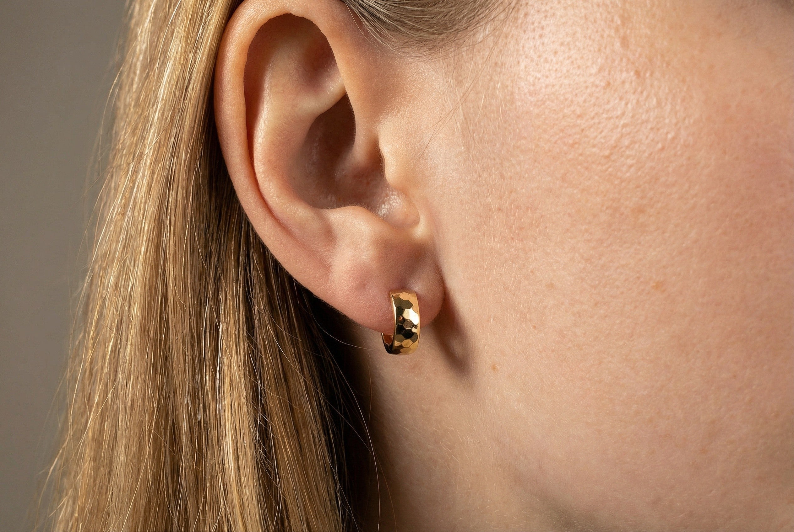 18K gold wide faceted hoop earrings on model, real gold women's jewelry