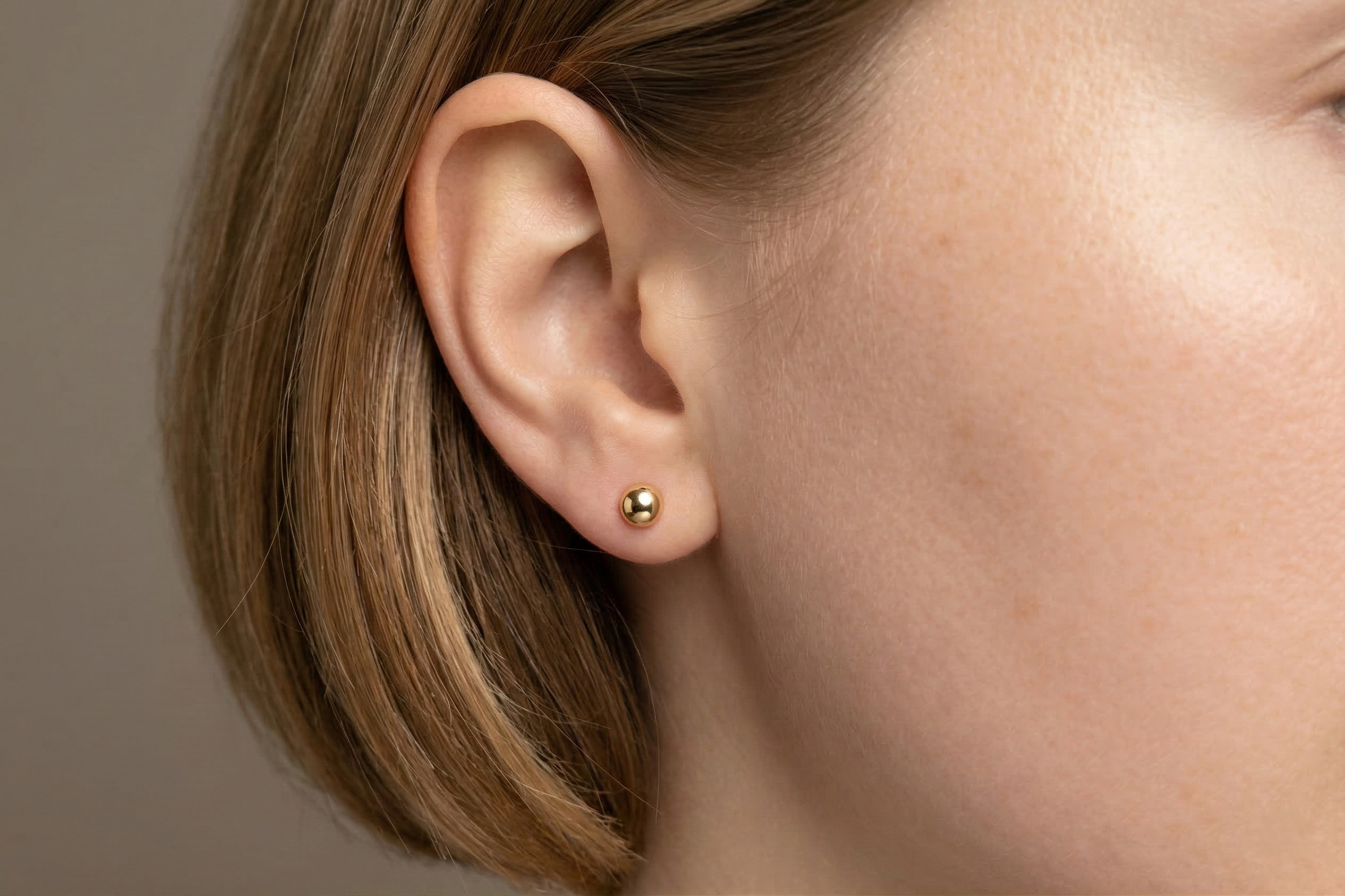 18K guldörhängen kula studs 5mm på modell, äkta guld dam