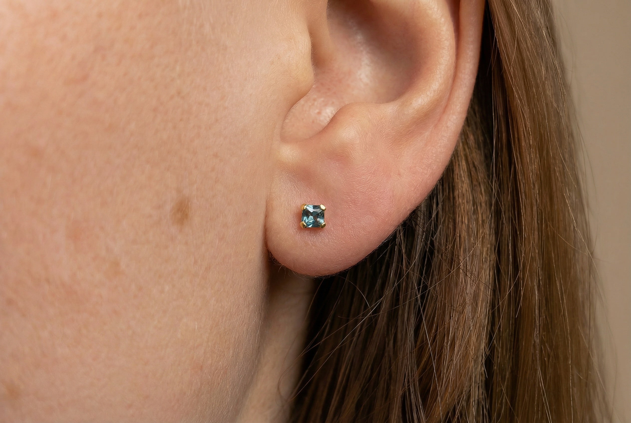 18K guldörhängen med blå zirkonia studs på modell, äkta guld dam