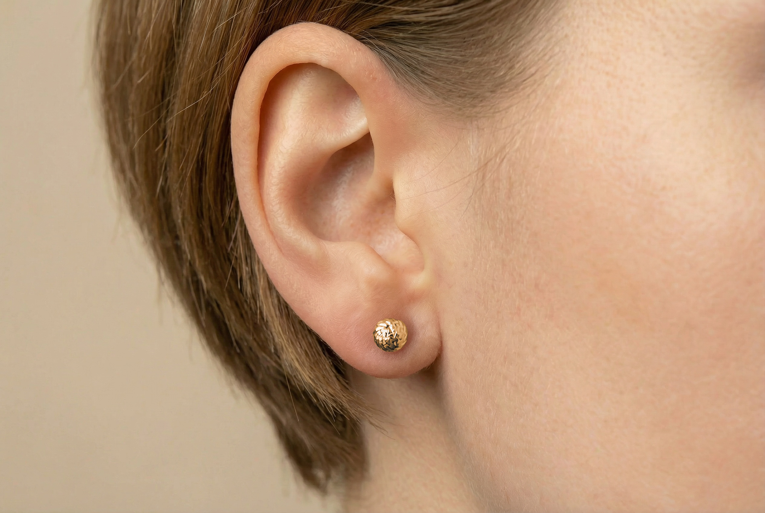 18K guldörhängen facetterad kula studs på modell, äkta guld dam
