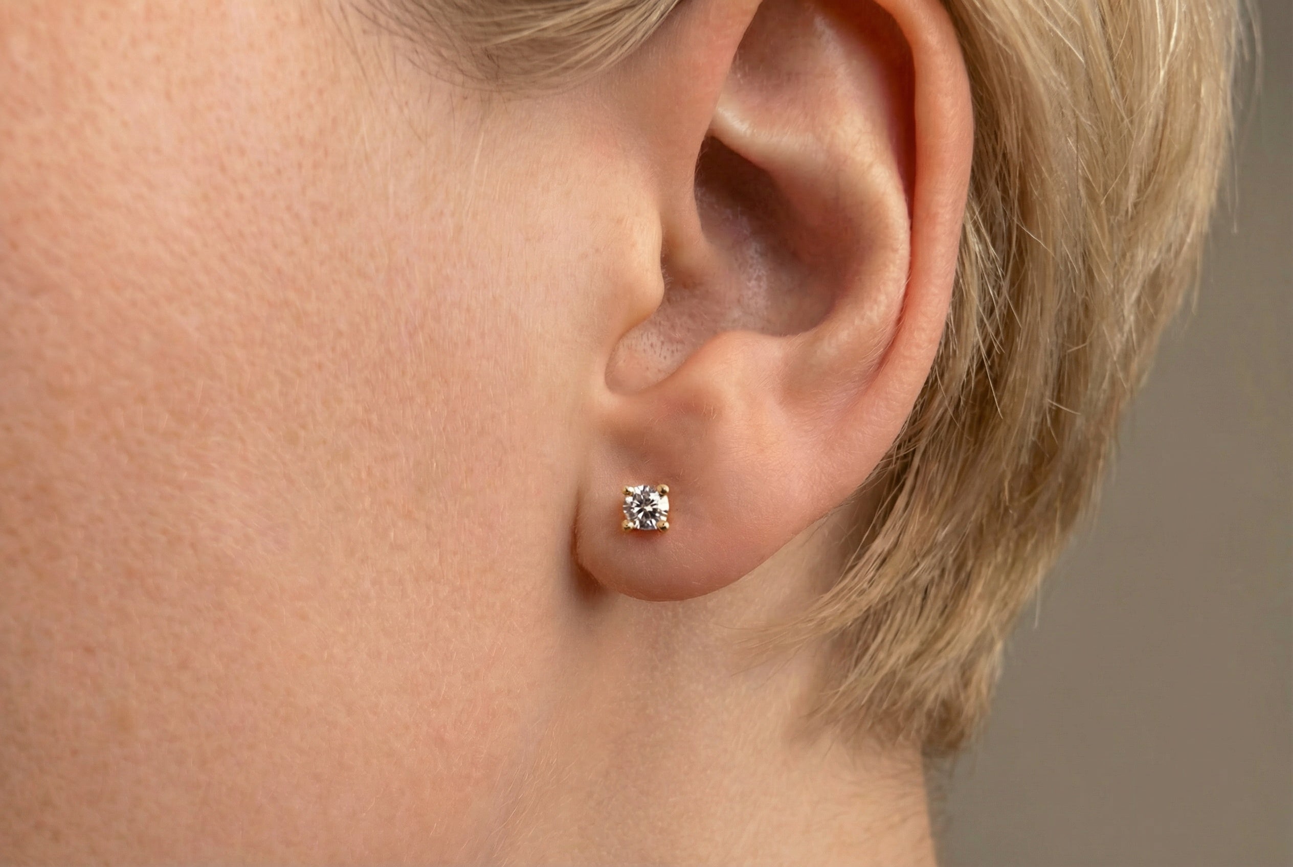 18K guldörhängen med zirkonia i kloinfattning studs på modell, äkta guld dam